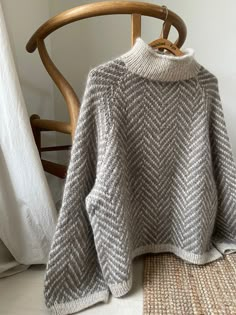 a gray sweater sitting on top of a wooden chair