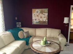 a living room with a white couch and coffee table in front of a painting on the wall