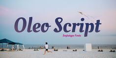 a girl running on the beach with a kite in the sky above her and an advertisement for oleeo script