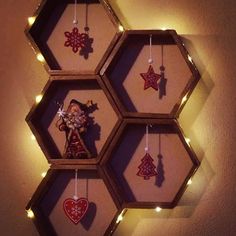 a hexagonal shelf with ornaments hanging from it's sides and lights around the shelves