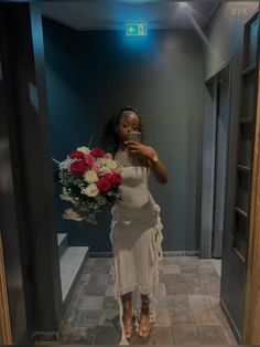 a woman is taking a selfie in the bathroom with flowers on her head and holding a cell phone