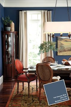 a dining room with blue walls and furniture