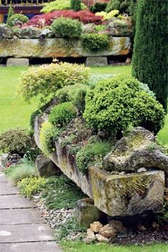 a stone bench sitting in the middle of a lush green park