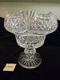 a crystal bowl sitting on top of a black tablecloth covered table next to a price tag