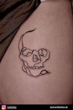 a woman's stomach with a skull tattoo on it