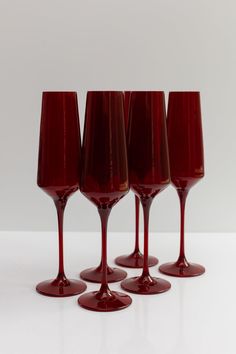 four red wine glasses sitting next to each other