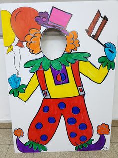 a cardboard box painted to look like a clown with balloons and a hat on it