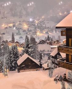 an image of a snowy mountain town at night with lights in the trees and snow on the ground