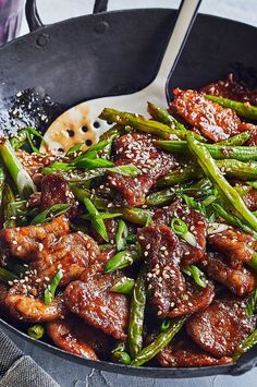 a skillet filled with meat and asparagus