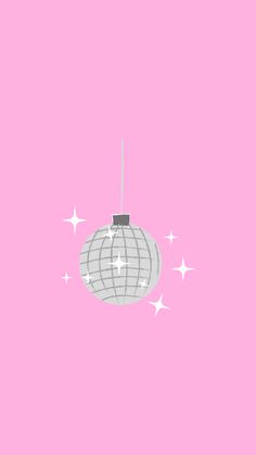 an ornament hanging from a string on a pink background with stars around it