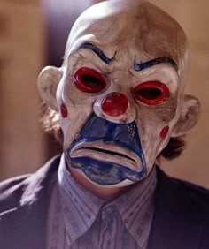 a man wearing a clown mask with red eyes