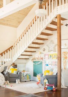 a living room filled with furniture under a stair case