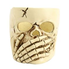 a white skull mug with two eyes and one eye opened to show the skeleton's face