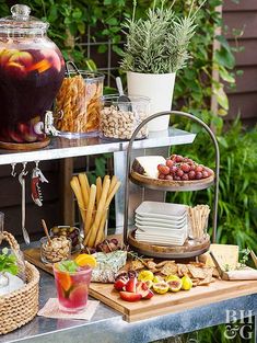 a table filled with food and drinks on top of a metal shelf next to plants