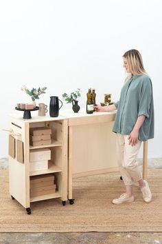 a woman standing next to a table with bottles on it