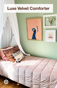 a bed with a pink comforter and pictures on the wall above it in a bedroom