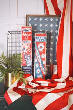 an american flag draped in front of some patriotic items on a mantle with other decorations