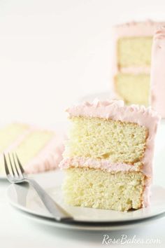 a slice of cake with pink frosting is on a plate next to a fork