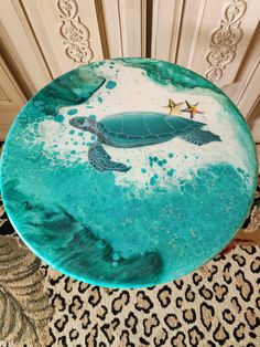 a cake decorated with a sea turtle and starfish on top of a leopard print tablecloth