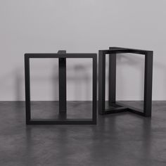 two black tables sitting on top of a cement floor