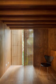 a chair sitting in the middle of a room with wooden slats on the walls