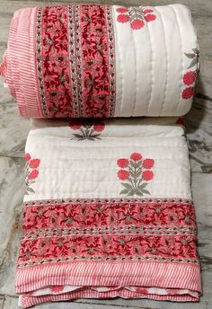 two red and white bedspreads sitting next to each other