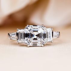 an emerald cut diamond ring with baguettes on the side