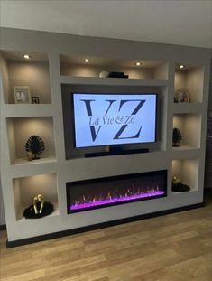 an entertainment center with built - in fireplaces and lighted shelves