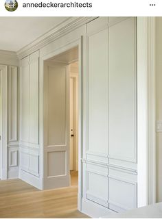 an empty room with white walls and wood floors