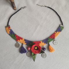 a multicolored beaded necklace with flowers and coins