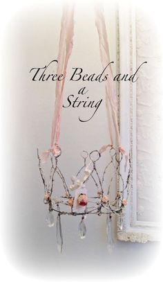 there is a tiara with pearls and pink ribbons on the headband that says, three beads and a string