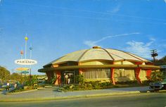 an old photo of the outside of a restaurant with cars parked in front of it