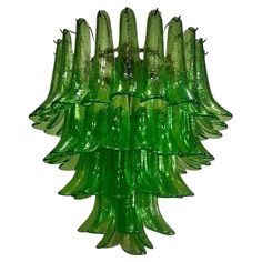 a green glass chandelier is hanging from the ceiling in front of a white background