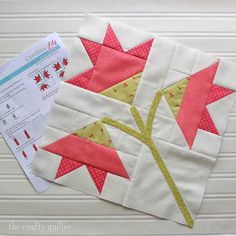 a close up of a piece of fabric on top of a white surface with a red and yellow flower