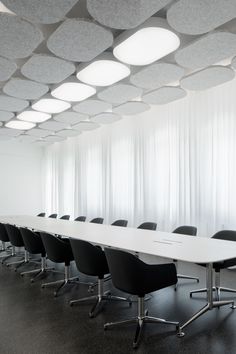 an empty conference room with white walls and black chairs