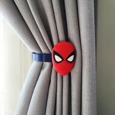 a spiderman mask hanging on the side of a curtain