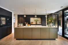 a modern kitchen with an island counter and glass doors that lead to the outside patio