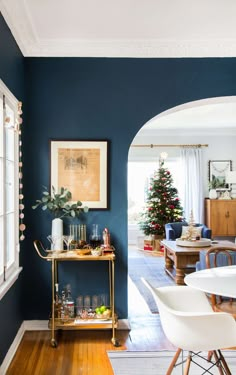 a living room with a christmas tree in the corner and other decorations on the table