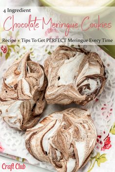 three chocolate meringue cookies sitting on top of a white plate next to a cup of coffee