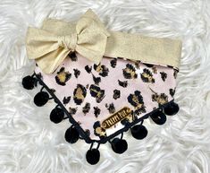 a pink and black animal print purse with a large bow on it's head