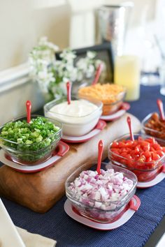 a table topped with bowls filled with different types of vegetables and dips on top of plates