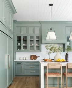 a kitchen with green cabinets and wooden floors