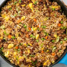 a skillet filled with rice, meat and vegetables