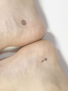 two people with small tattoos on their legs, one has a key and the other has a heart