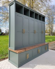 a large gray cabinet sitting on top of a cement floor next to a green field