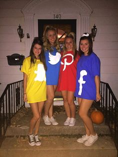 four girls dressed in halloween costumes standing on the front steps of a house with pumpkins