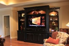 a living room with a large entertainment center in the middle of it's wall