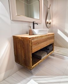 a bathroom with a sink, mirror and wooden cabinet