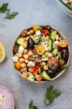 a bowl filled with chickpeas, cucumber, tomatoes and other vegetables