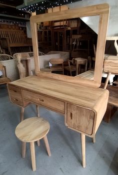 a wooden dressing table with mirror and stool